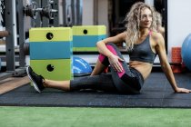 Beautiful woman performing stretching exercise in gym — Stock Photo