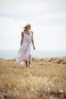 Bella donna bionda a piedi nel campo vicino al fiume — Foto stock