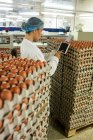 Жінка-працівник використовує цифровий планшет на яєчній фабриці — стокове фото