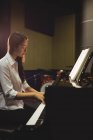 Étudiante jouant du piano en studio — Photo de stock