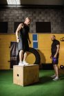 Два спортсмена работают над деревянной коробкой в фитнес-студии — стоковое фото
