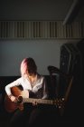 Жінка грає на гітарі в музичній школі — стокове фото