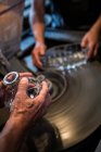 Hands of glassblowers working on a glass at glassblowing factory — Stock Photo