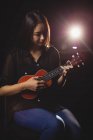 Mulher bonita tocando uma guitarra na escola de música — Fotografia de Stock