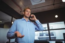 Business man talking on the mobile phone in office — Stock Photo