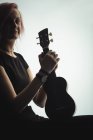 Портрет жінки, що сидить з гітарою в музичній школі — стокове фото