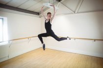 Jeune Ballerino sauter tout en pratiquant la danse de ballet en studio — Photo de stock