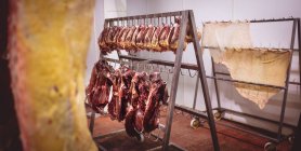 Beef hearts and meat hanging in the storage room at butchers shop — Stock Photo