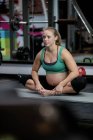 Pregnant woman performing stretching exercise on exercise mat in gym — Stock Photo