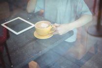 Mujer tomando café en la cafetería - foto de stock