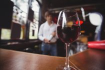 Gros plan du verre avec du vin rouge sur le comptoir du bar — Photo de stock