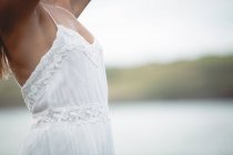 Mid section of woman in white summer dress outdoors — Stock Photo