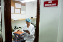 Жіночий співробітників, що використовують цифровий планшетний під час роботи в яйце заводу — стокове фото