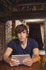 Retrato de homem usando tablet digital com copo de cerveja na mesa no bar — Fotografia de Stock