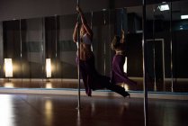 Танцовщица на шесте практикует в студии — стоковое фото