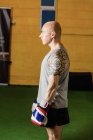 Seitenansicht eines Boxers, der mit Boxhandschuhen im Fitnessstudio steht — Stockfoto