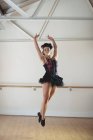 Ballerina in black tutu practicing ballet dance in studio — Stock Photo