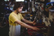 Mechaniker sucht Werkzeuge aus Werkzeugkiste in Werkstatt aus — Stockfoto