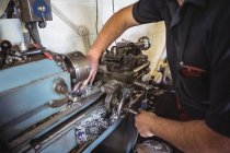 Mechaniker arbeitet in Werkstatt an Drehmaschine — Stockfoto