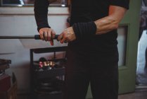 Cropped image of Glassblower holding blowpipe at glassblowing factory — Stock Photo