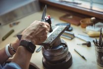 Руки ремесленницы с помощью инструментов в мастерской — стоковое фото