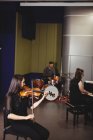 Zwei Studentinnen spielen Geige und Klavier in einem Studio — Stockfoto