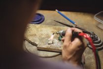Craftswoman using blow torch in workshop — Stock Photo