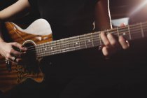 Mid-section female student playing guitar in a studio — Stock Photo
