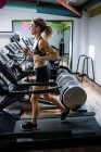 Beautiful woman exercising on treadmill at gym — Stock Photo