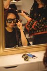 Стильна жінка в сонцезахисних окулярах робить волосся в професійному перукарні — стокове фото