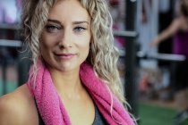 Портрет красивої жінки з рушником навколо шиї в спортзалі — стокове фото