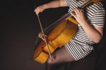 Mid-section of female student playing double bass in a studio — Stock Photo