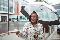 Sonriente Hermosa mujer disfrutando de la lluvia durante la temporada de lluvias - foto de stock