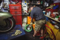 Mechaniker gießt Öl in Ölfass in Werkstatt — Stockfoto