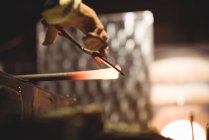 Стеклодув, работающий на расплавленном стекле на стекольном заводе — стоковое фото
