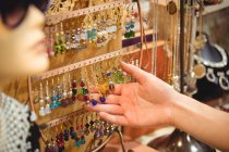 Mano de una mujer sosteniendo joyas vintage en una tienda de antigüedades - foto de stock