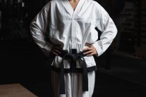 Mittelteil der Karate-Frau steht mit den Händen auf den Hüften im Fitnessstudio — Stockfoto