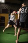 Due pugili di calcio che praticano la boxe in palestra — Foto stock