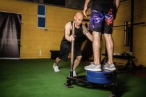 Boxeadores tailandeses practicando ejercicio con pesas en gimnasio - foto de stock