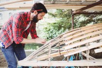 Uomo preparazione cornice barca in legno in cantiere — Foto stock