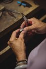 Hände von Handwerkerin halten Zange in Werkstatt — Stockfoto