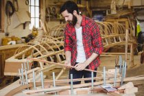 Uomo preparazione cornice barca in legno in cantiere — Foto stock