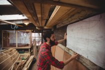 Man looking at blueprint in boatyard interior — Stock Photo