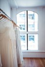 Various wedding dress hanging on clothes line in a shop in studio — Stock Photo