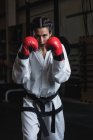 Retrato de mujer confiada en guantes de boxeo en el gimnasio - foto de stock
