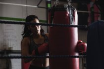 Boxerin übt Boxen mit Boxsack im Fitnessstudio — Stockfoto