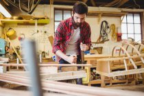 Чоловік працює над дерев'яною дошкою на дошці — стокове фото