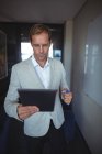 Geschäftsmann schaut im Büro auf digitales Tablet — Stockfoto