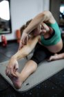 Selective focus of Pregnant woman performing stretching exercise on exercise mat in gym — Stock Photo