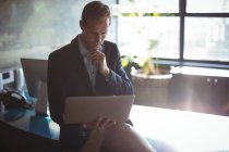 Empresário atencioso usando laptop no escritório — Fotografia de Stock